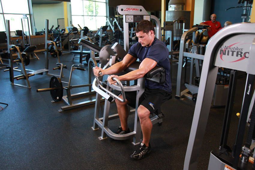 Machine Preacher Curl exercise demonstration, targeting the biceps